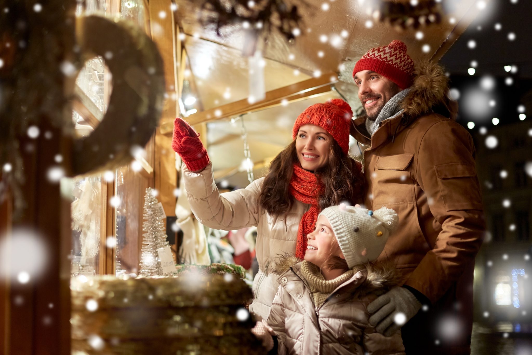 Happy family at Christmas market in city