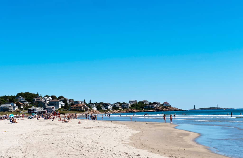 Families enjoying a sandy beach in Gloucester on a sunny summer day