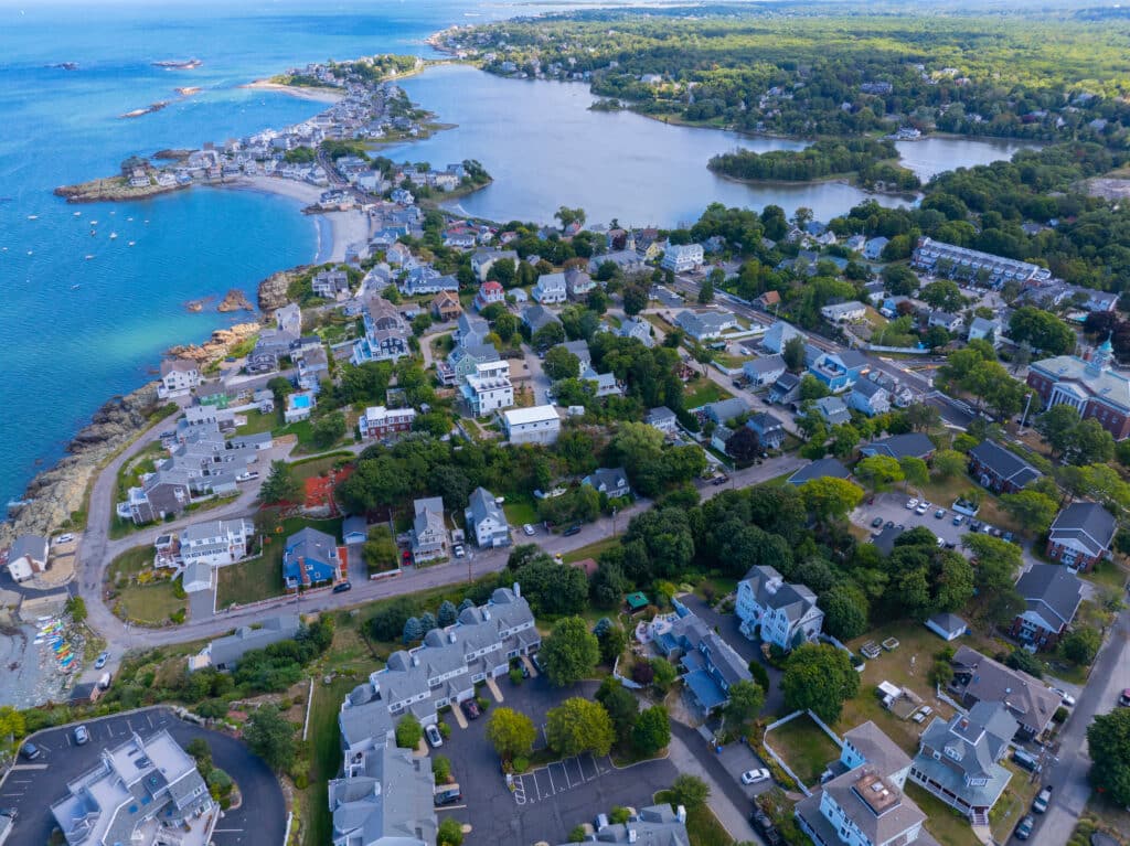 Aerial view of a coastal Boston-area town with beaches, waterfront homes, and scenic shoreline