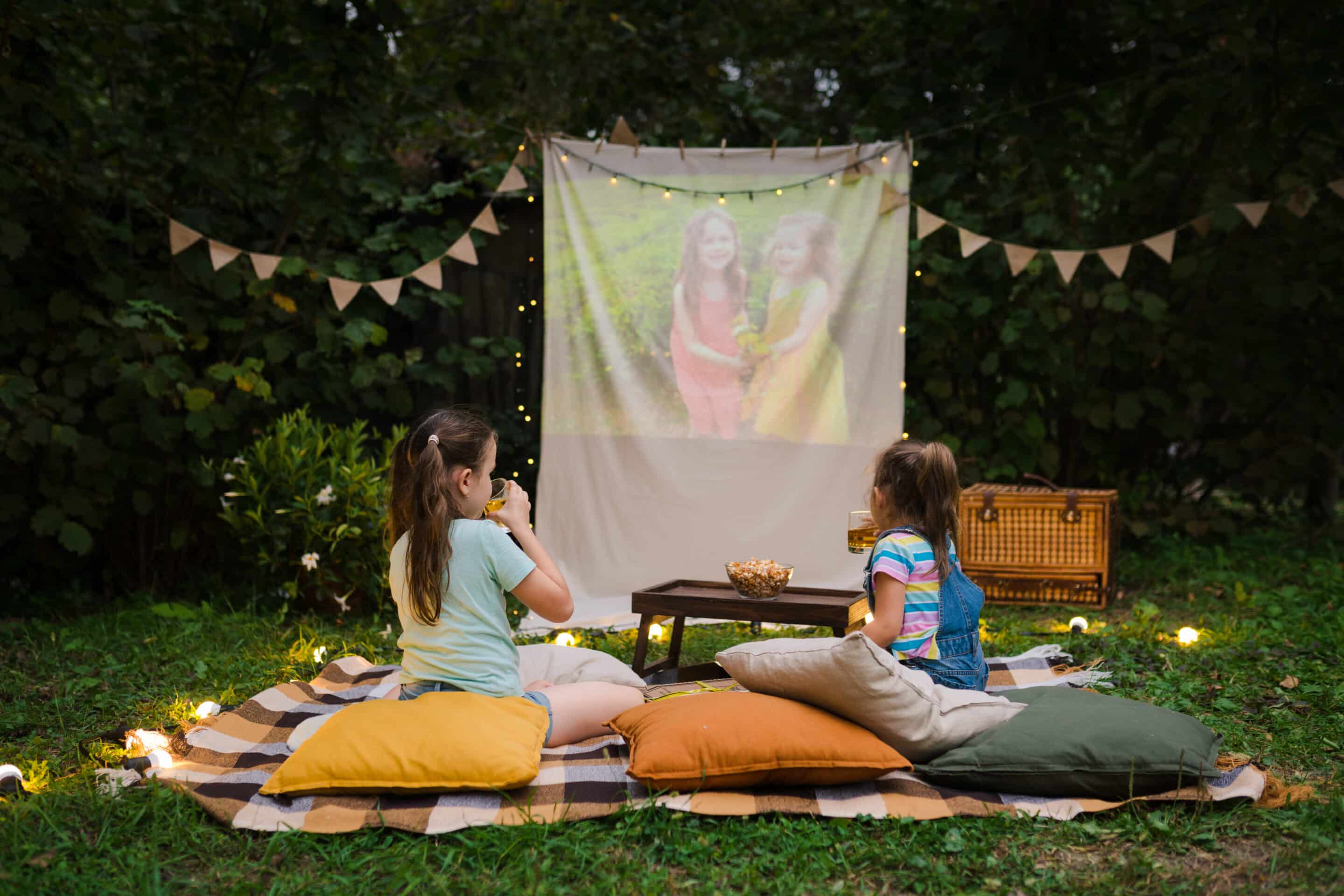 Outdoor Entertaining in a Suburban Backyard Children enjoying an outdoor movie night in a suburban backyard