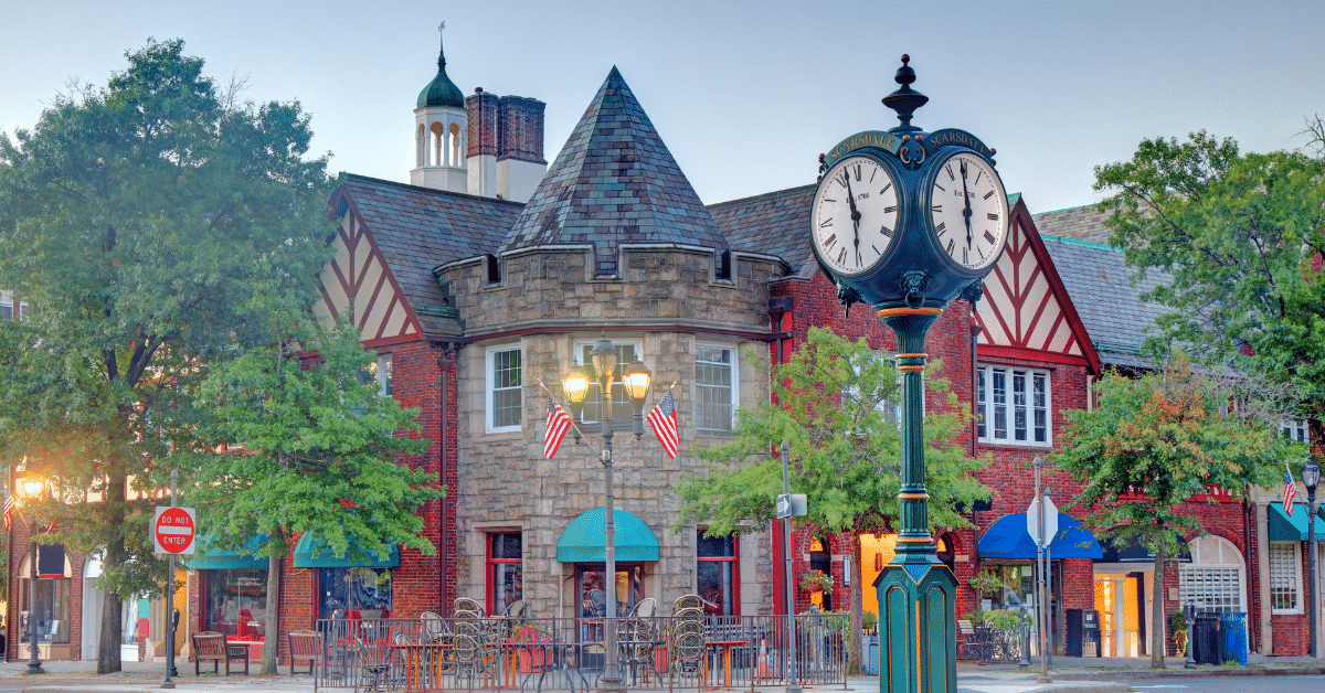 Scarsdale Village – Living in Scarsdale, NY Scarsdale Village in Scarsdale, NY, featuring its landmark street clock, Tudor-style buildings, outdoor dining, and shops.